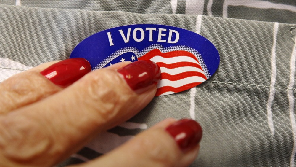 A voter receives a sticker from a polling station worker after he cast his ballot in the Super Tuesday election at Sleepy Hollow Elementary School in Falls Church, Va, March 1, 2016. (Photo by Kevin Lamarque/Reuters)