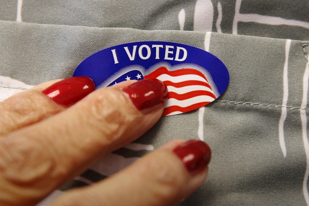 A voter receives a sticker from a polling station worker after he cast his ballot in the Super Tuesday election at Sleepy Hollow Elementary School in Falls Church, Va, March 1, 2016. (Photo by Kevin Lamarque/Reuters)