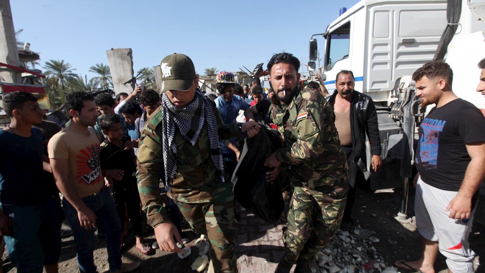 Members of the Hashid Shaabi Shi'ite militia carry the body of a victim of a bomb attack at a checkpoint in the city of Hilla, south of Baghdad, March 6, 2016. (Photo by Alaa Al-Marjani/Reuters)
