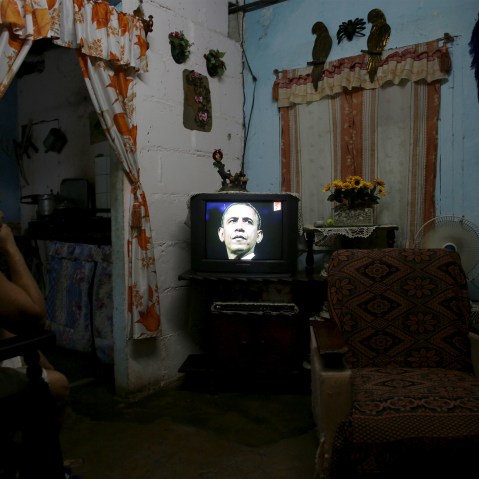 Marcia Espinosa, 55, watches pictures of U.S. President Barack Obama being shown during a local TV news program in her home in Havana, March 19, 2016. (Photo by Alexandre Meneghini/Reuters)