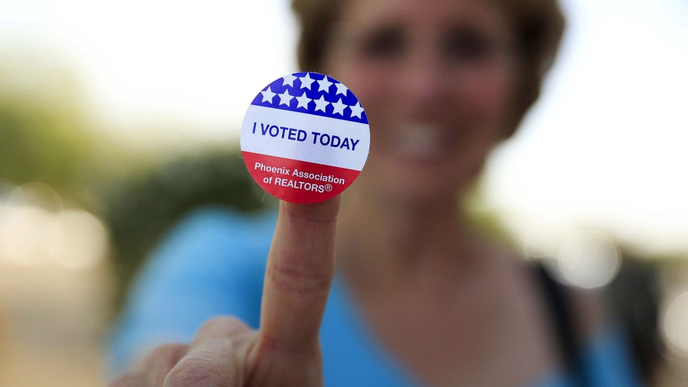 Deborah Kelly, who waited in line 45 minutes to vote in the presidential primary election, shows her voting sticker outside a polling site in Glendale, Ariz., March 22, 2016. (Photo by Nancy Wiechec/Reuters)