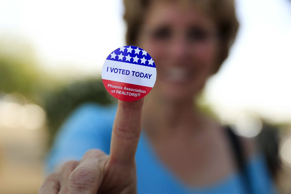 Deborah Kelly, who waited in line 45 minutes to vote in the presidential primary election, shows her voting sticker outside a polling site in Glendale, Ariz., March 22, 2016. (Photo by Nancy Wiechec/Reuters)