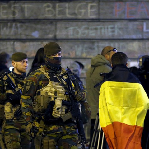 Belgian soldiers patrol as people pay tribute to the victims of Tuesday's bomb attacks at the Place de la Bourse in Brussels, Belgium, March 26, 2016. (Photo by Francois Lenoir/Reuters)