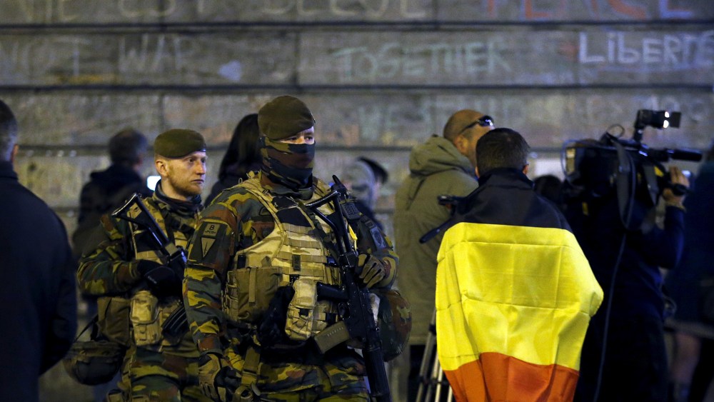 Belgian soldiers patrol as people pay tribute to the victims of Tuesday's bomb attacks at the Place de la Bourse in Brussels, Belgium, March 26, 2016. (Photo by Francois Lenoir/Reuters)