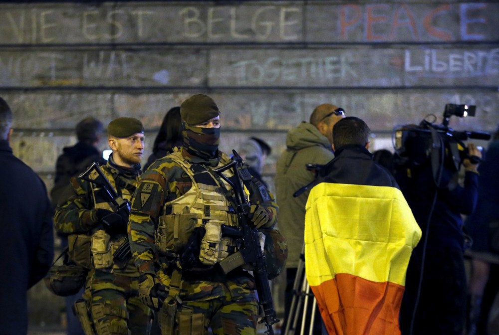 Belgian soldiers patrol as people pay tribute to the victims of Tuesday's bomb attacks at the Place de la Bourse in Brussels, Belgium, March 26, 2016. (Photo by Francois Lenoir/Reuters)