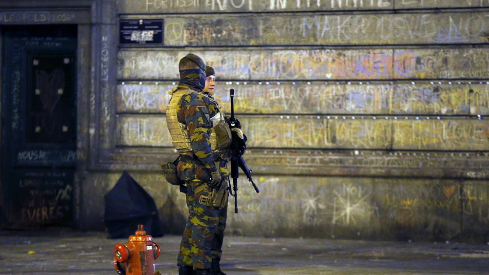 Belgian soldiers patrol, as people pay tribute to the victims of Tuesday's bomb attacks, at the Place de la Bourse in Brussels, Belgium, March 26, 2016. (Photo by Francois Lenoir/Reuters)