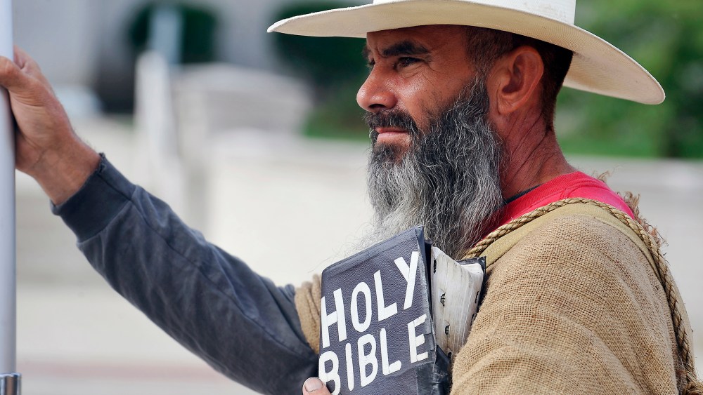 Allan Hoyle, of North Carolina, stands with bible in hand in support of Kim Davis at the Rowan County Judicial Center, Sep. 9, 2015. (Photo by Chris Tilley/Reuters)