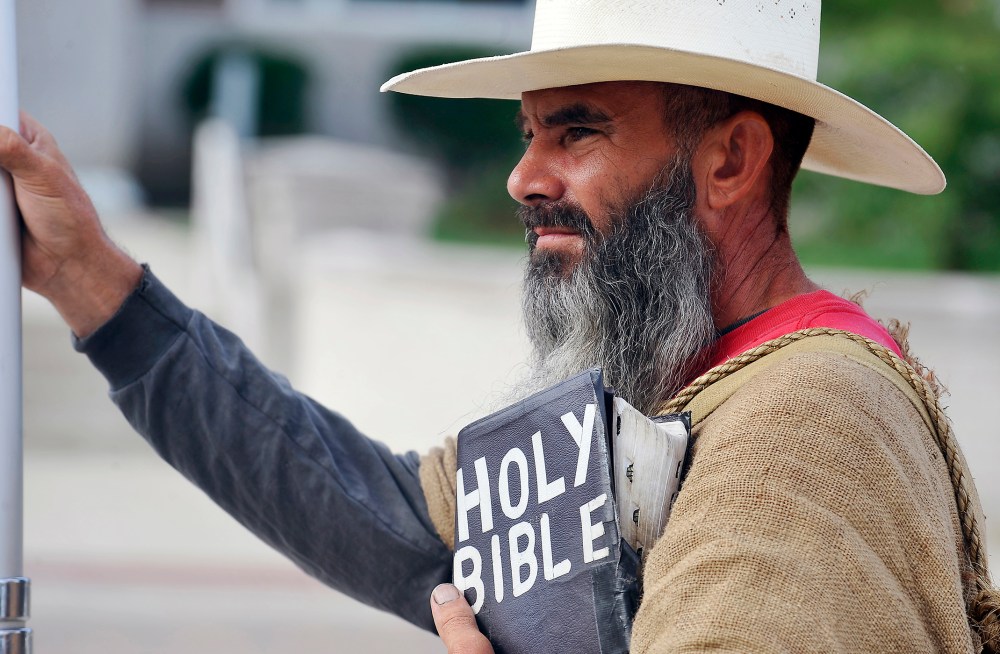 Allan Hoyle, of North Carolina, stands with bible in hand in support of Kim Davis at the Rowan County Judicial Center, Sep. 9, 2015. (Photo by Chris Tilley/Reuters)