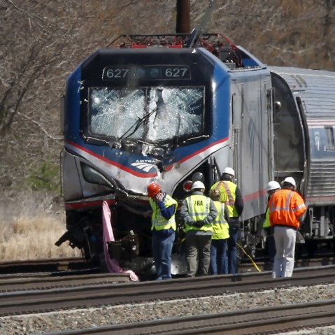 Emergency personnel examine the scene after an Amtrak passenger train struck a backhoe, killing two people, in Chester, Penn., April 3, 2016. (Photo by Dominick Reuter/Reuters)