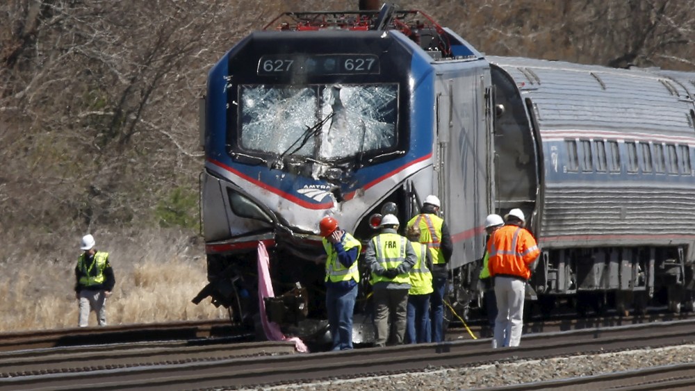 Emergency personnel examine the scene after an Amtrak passenger train struck a backhoe, killing two people, in Chester, Penn., April 3, 2016. (Photo by Dominick Reuter/Reuters)