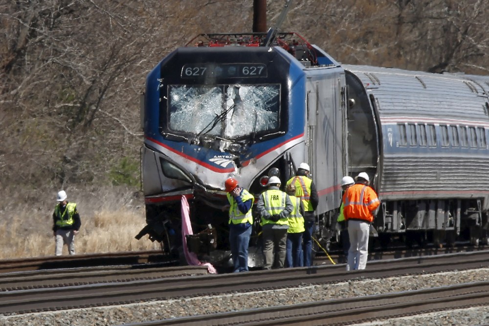 Emergency personnel examine the scene after an Amtrak passenger train struck a backhoe, killing two people, in Chester, Penn., April 3, 2016. (Photo by Dominick Reuter/Reuters)