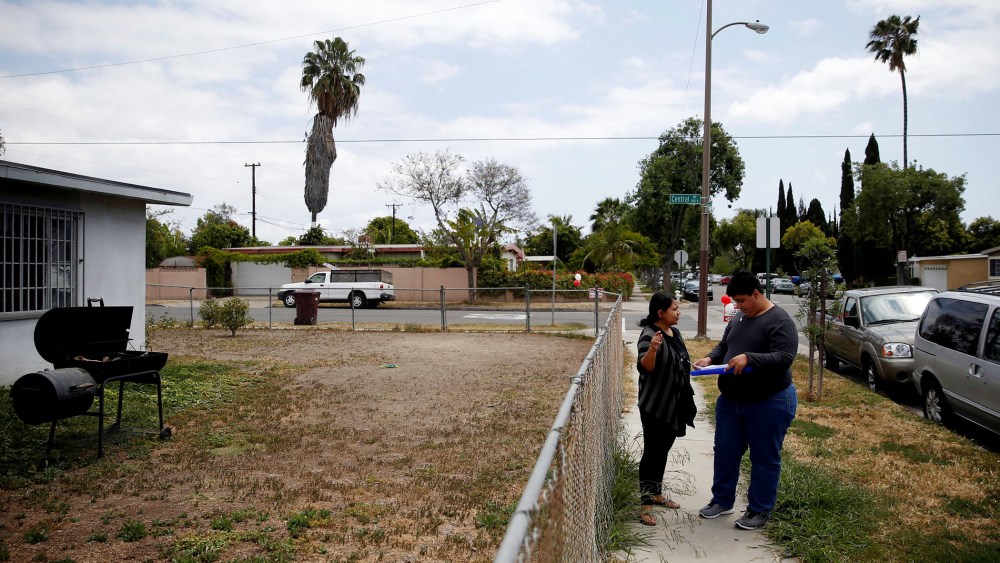 America Najera, 32, and Juan Munoz, 18, of the Democratic Party of Orange County check a voter registration list as they canvass a neighborhood ahead of the California Primary election, Santa Ana, Calif., May 15, 2016. (Photo by Patrick T. Fallon/Reuters)
