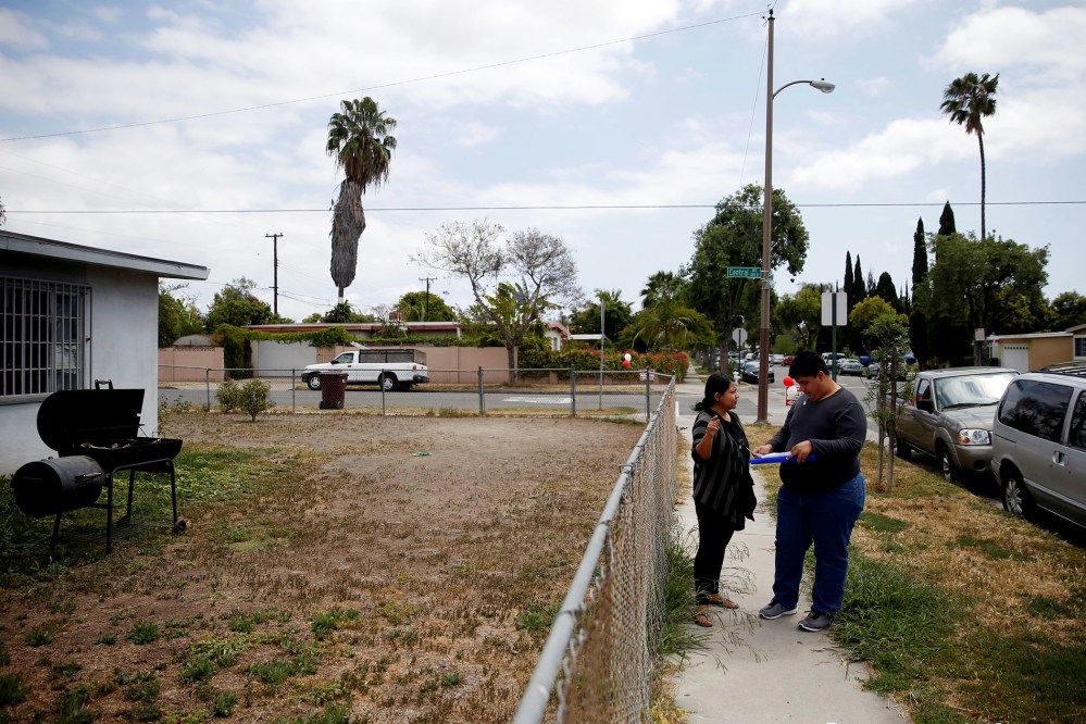 America Najera, 32, and Juan Munoz, 18, of the Democratic Party of Orange County check a voter registration list as they canvass a neighborhood ahead of the California Primary election, Santa Ana, Calif., May 15, 2016. (Photo by Patrick T. Fallon/Reuters)
