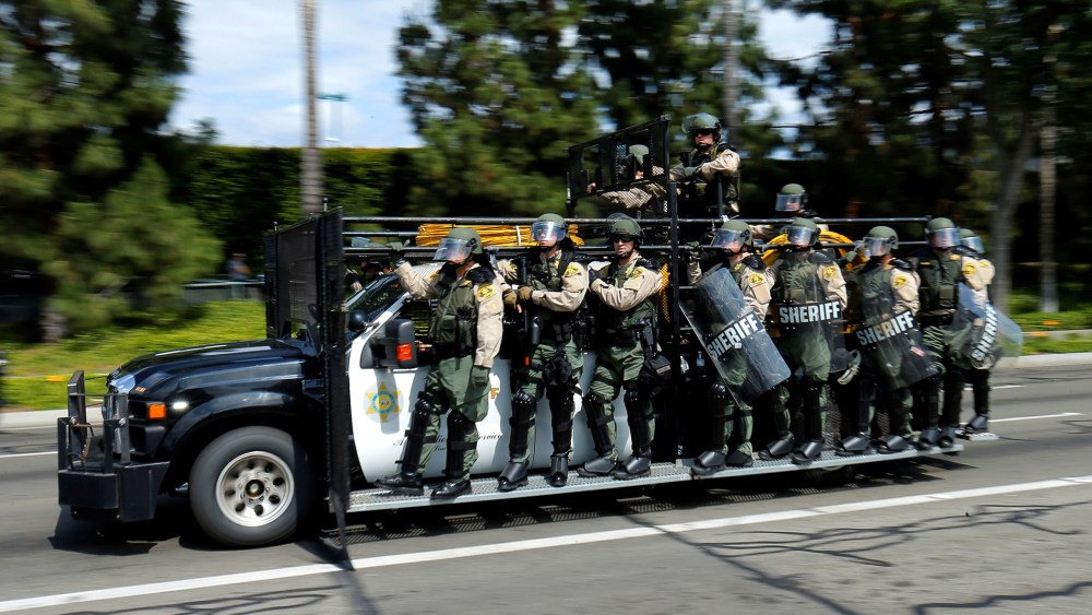 Los Angeles County Sheriffs in riot gear chase demonstrators near Donald Trump's campaign rally in Anaheim, Calif., May 25, 2016. (Photo by Mike Blake/AP)