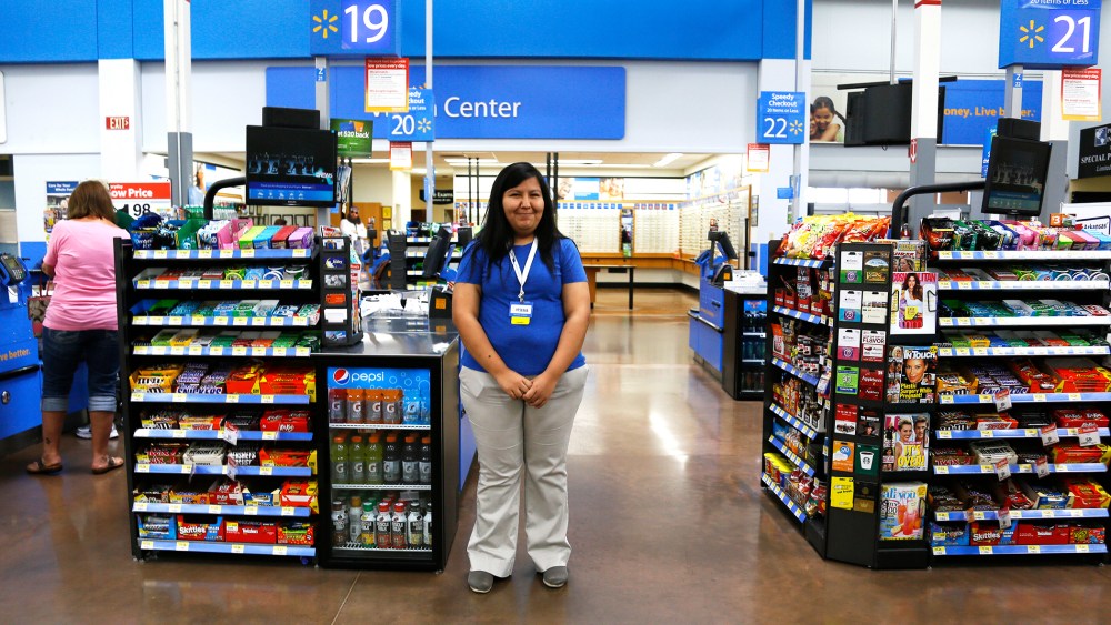 A cashier waits for customers at a Walmart Supercenter in Rogers, Arkansas June 6, 2013.