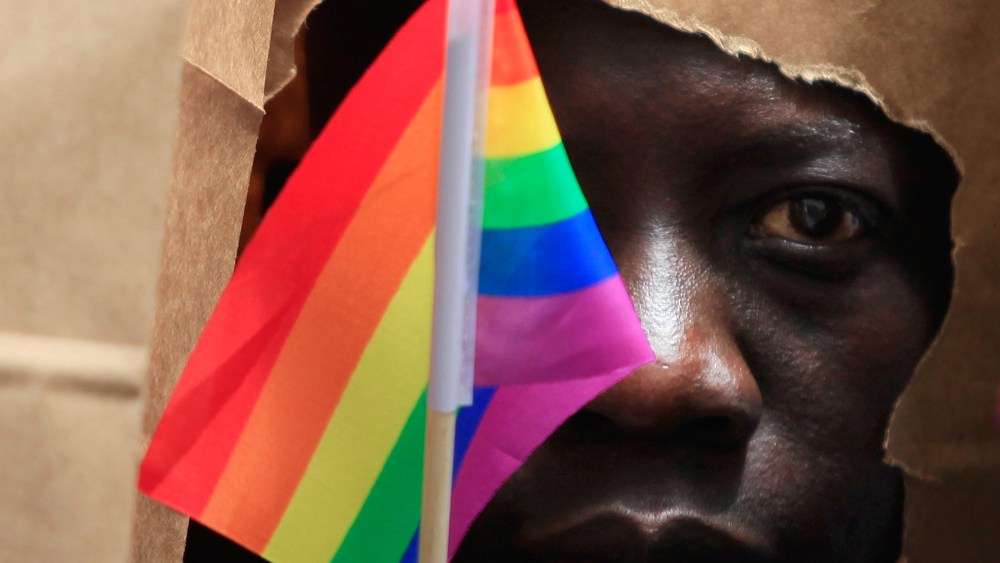 An asylum seeker from Uganda covers his face with a paper bag in order to protect his identity as he marches with the LGBT Asylum Support Task Force during the Gay Pride Parade in Boston, Mass., June 8, 2013. (Photo by Jessica Rinaldi/Reuters)