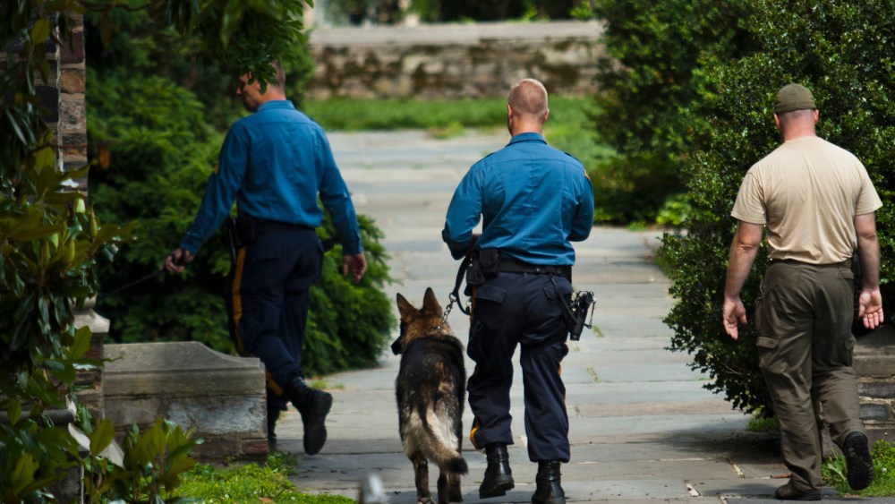 New Jersey police officers patrol on foot with dogs inside the campus of Princeton University in New Jersey June 11, 2013. (Photo by Eduardo Munoz/Reuters)