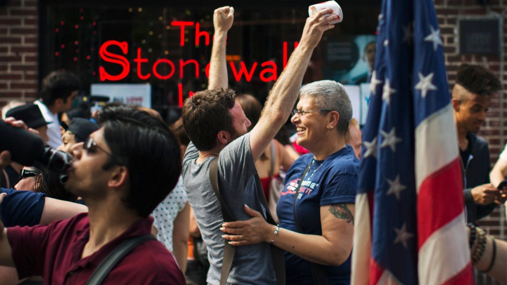 People embrace and cheer as they join a crowd celebrating the U.S. Supreme Court ruling against the Defense of Marriage Act outside the Stonewall Inn in N.Y. on June 26, 2013. (Photo by Lucas Jackson/Reuters)