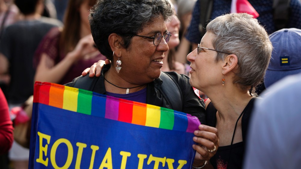 Carmen Castro carries an "Equality" flag as she greets Wind Vogel while celebrating the U.S. Supreme Court ruling against the Defense of Marriage Act outside the Stonewall Inn, June 26, 2013. (Photo by Lucas Jackson/Reuters)