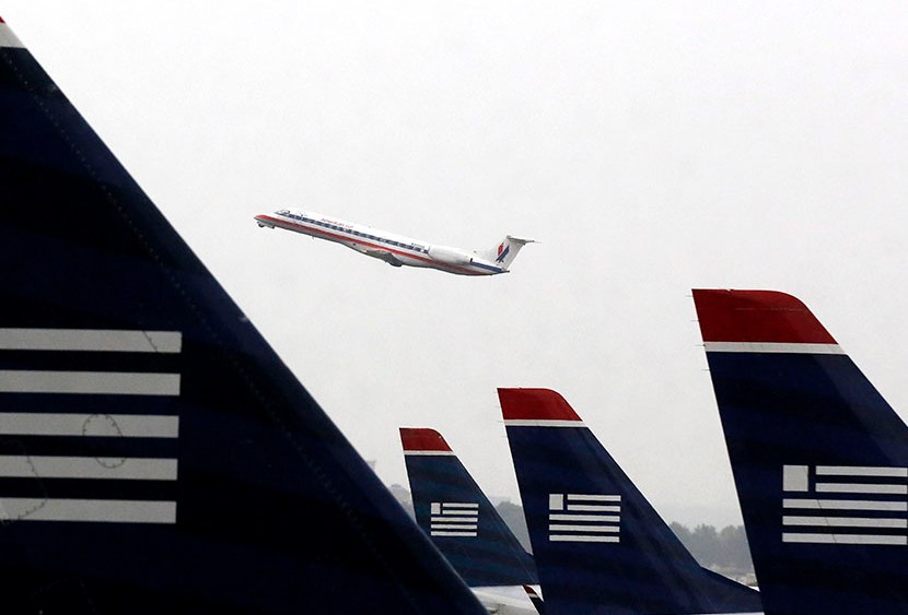 An American Eagle Embraer ERJ-140LR jet takes off as U.S. Airways jets are lined up at Reagan National Airport in Washington July 12, 2013. (Photo by Larry Downing/Reuters)a