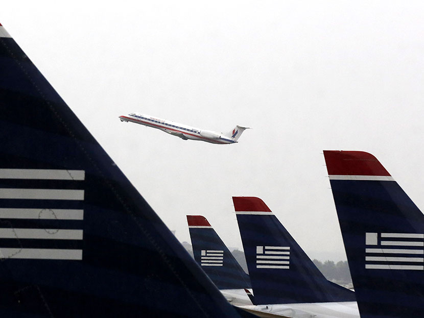 An American Eagle Embraer ERJ-140LR jet takes off as U.S. Airways jets are lined up at Reagan National Airport in Washington July 12, 2013. (Photo by Larry Downing/Reuters)a