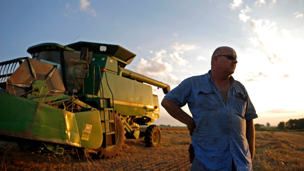 Farmer Jim Schielein stands by is combine after a day of harvesting soft red winter wheat in Dixon, Illinois