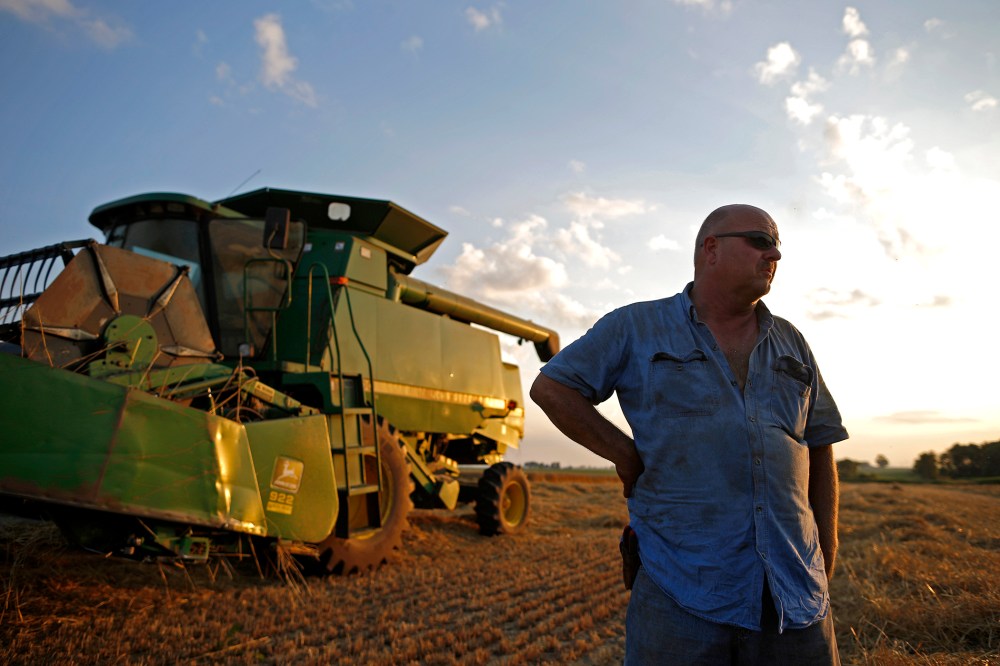 Farmer Jim Schielein stands by is combine after a day of harvesting soft red winter wheat in Dixon, Illinois