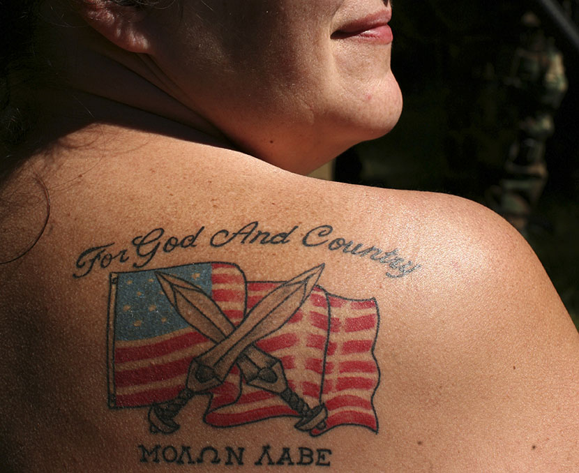 Female soldier from the 63rd battalion from Spokane, Washington, displays her tattoo during the Light Foot Militia annual gathering on Bureau of Land Management land near Priest River, Idaho June 23, 2013. (Photo by Matt Mills/AP)