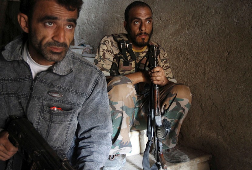 Free Syrian Army fighters take up position on the stairs of a building in Aleppo's Salaheddine neighborhood on July 23, 2013. (Photo by Muzaffar Salman/Reuters)