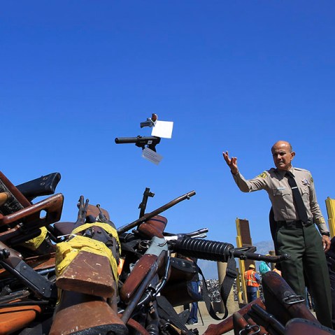 Los Angeles County Sheriff Lee Baca tosses a pistol onto a pile of guns to be melted at the Los Angeles County Sheriff's Department's 20th annual Gun Melt at the Gerdau Steel Mill in Rancho Cucamonga, California, July 30, 2013. Thousands of weapons...