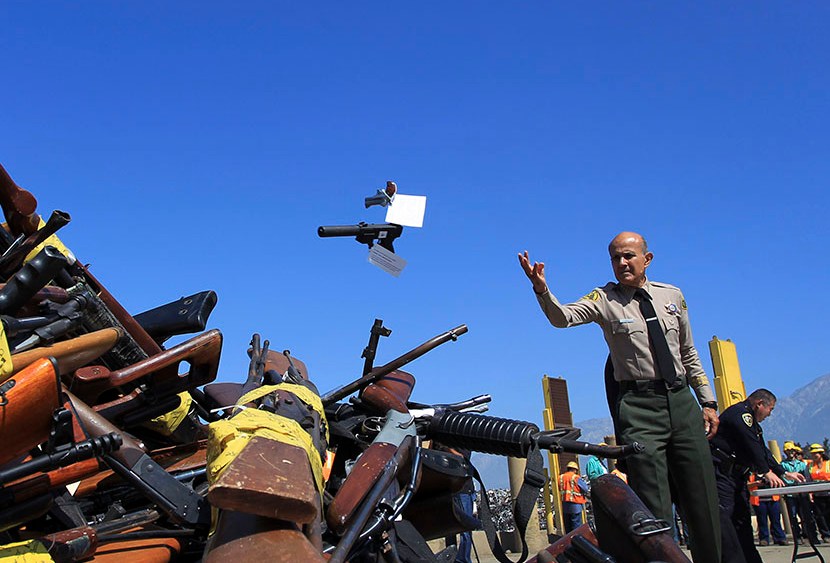Los Angeles County Sheriff Lee Baca tosses a pistol onto a pile of guns to be melted at the Los Angeles County Sheriff's Department's 20th annual Gun Melt at the Gerdau Steel Mill in Rancho Cucamonga, California, July 30, 2013. Thousands of weapons...
