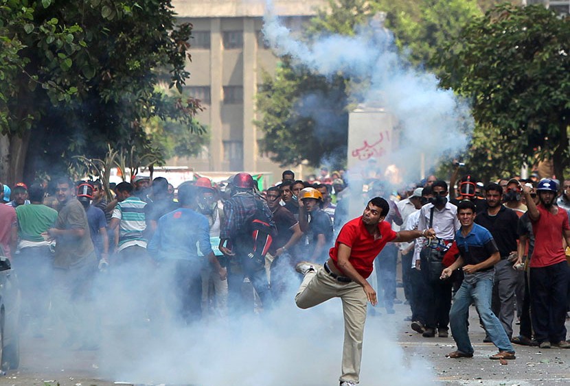 A supporter of ousted President Mohamed Mursi throws a tear gas canister back towards the police during clashes in central Cairo August 13, 2013. (Photo by Asmaa Waguih/Reuters)