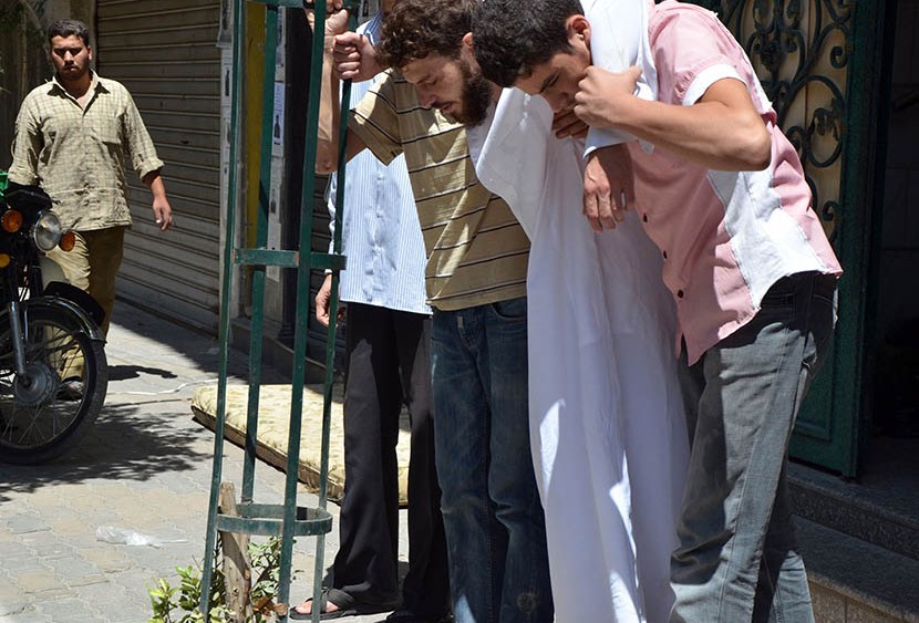 Survivors from what activists say is a gas attack are seen along a street in the Duma neighbourhood of Damascus