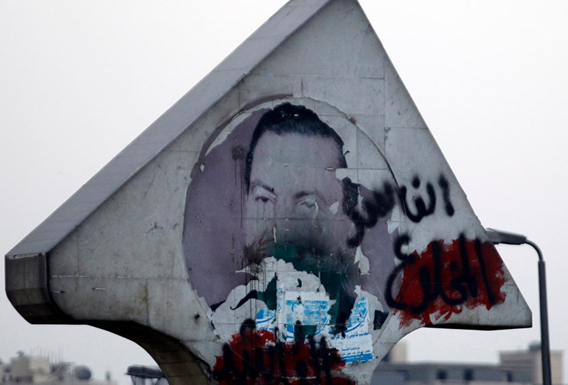 A defaced picture of former Egyptian President Hosni Mubarak with graffiti that reads, "Corrupt and deposed" along a highway in Cairo