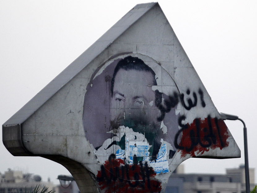 A defaced picture of former Egyptian President Hosni Mubarak with graffiti that reads, "Corrupt and deposed" along a highway in Cairo