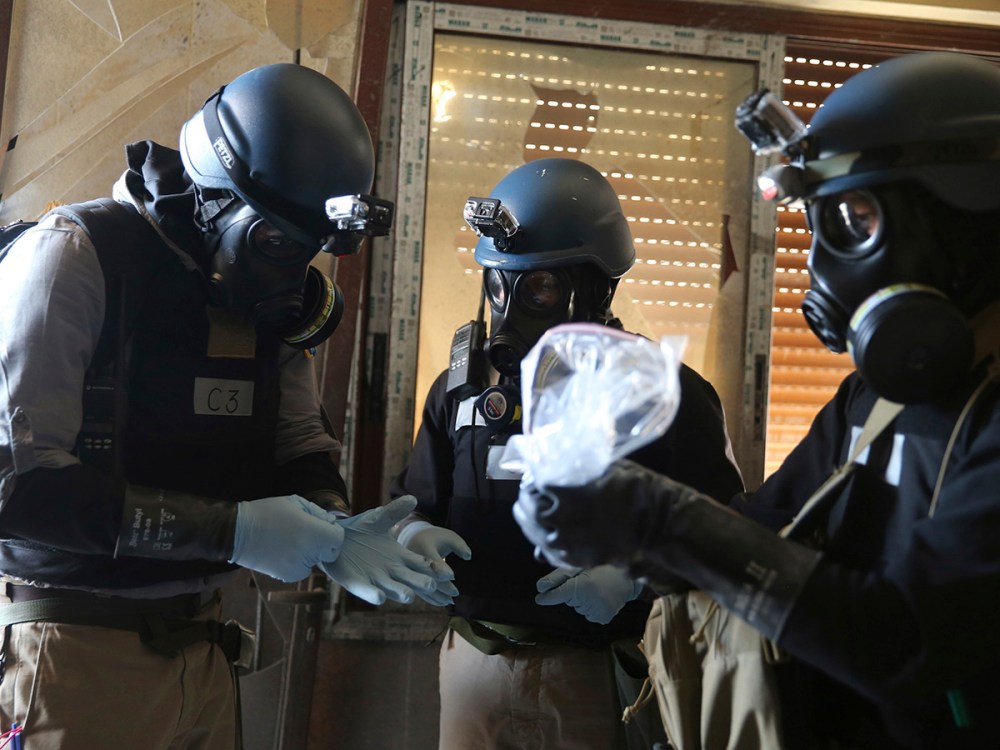 A U.N. chemical weapons expert holds a plastic bag containing samples from one of the sites of an alleged chemical weapons attack in Ain Tarma