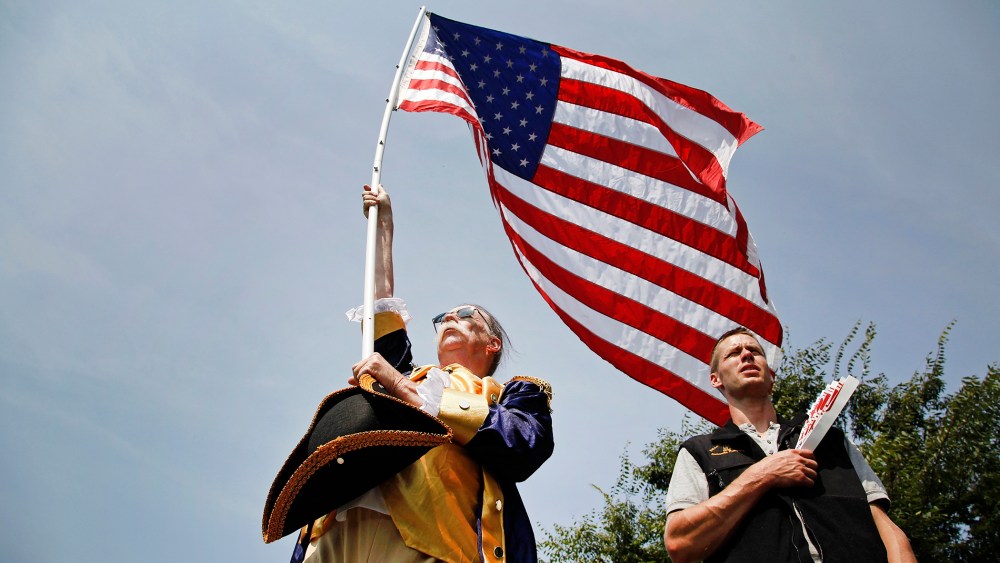 People stand for the national anthem at a Tea Party Patriots rally on the west lawn of the U.S. Capitol, Sept. 10, 2013.