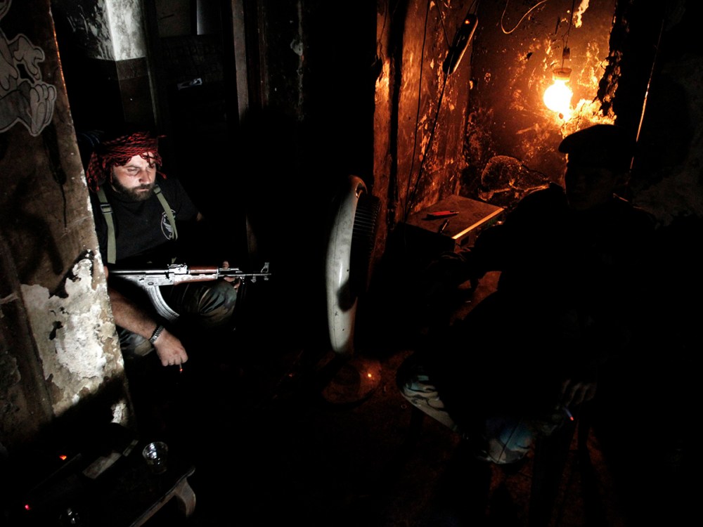 Free Syrian Army fighters smoke cigarettes as they rest in Aleppo's Qastal al-Harami neighbourhood