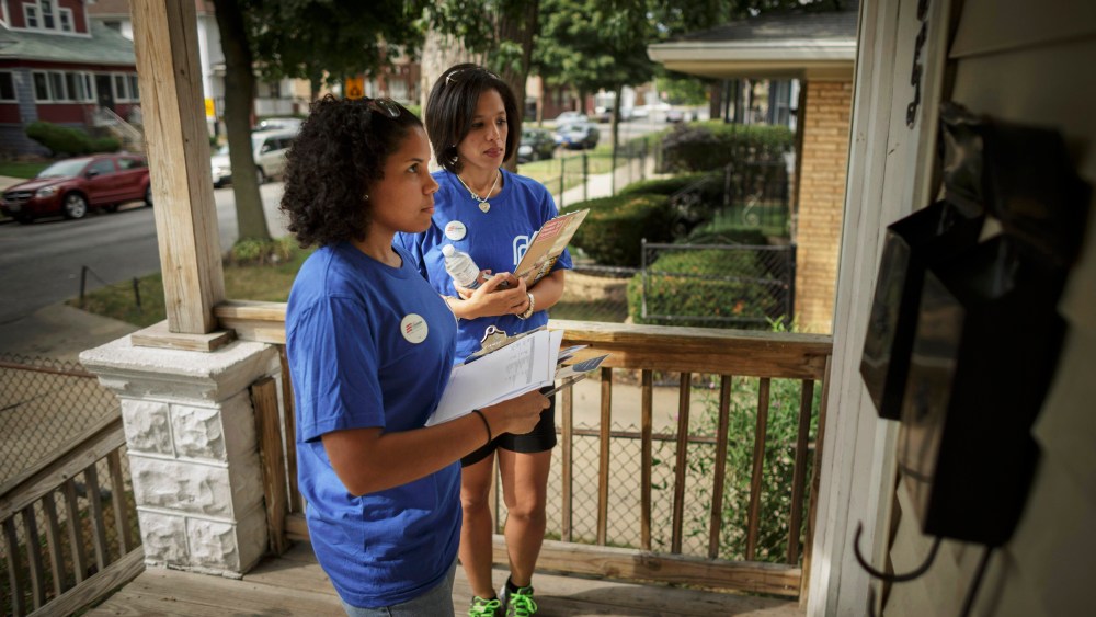 Get Covered America volunteers wait on a porch as they try to talk with one of the residents about the Affordable Care Act in Chicago, September 7, 2013.