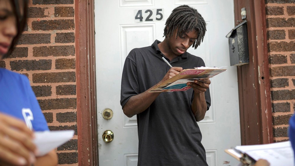 Get Covered America volunteers Cynae Derose (L) and Jalisa Hinkle talk with Daniel Glover about the Affordable Care Act - also known as Obamacare - while canvassing a Chicago, Illinois neighborhood September 7, 2013.