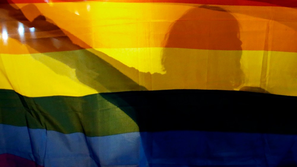A gay rights activist holds a rainbow flag.