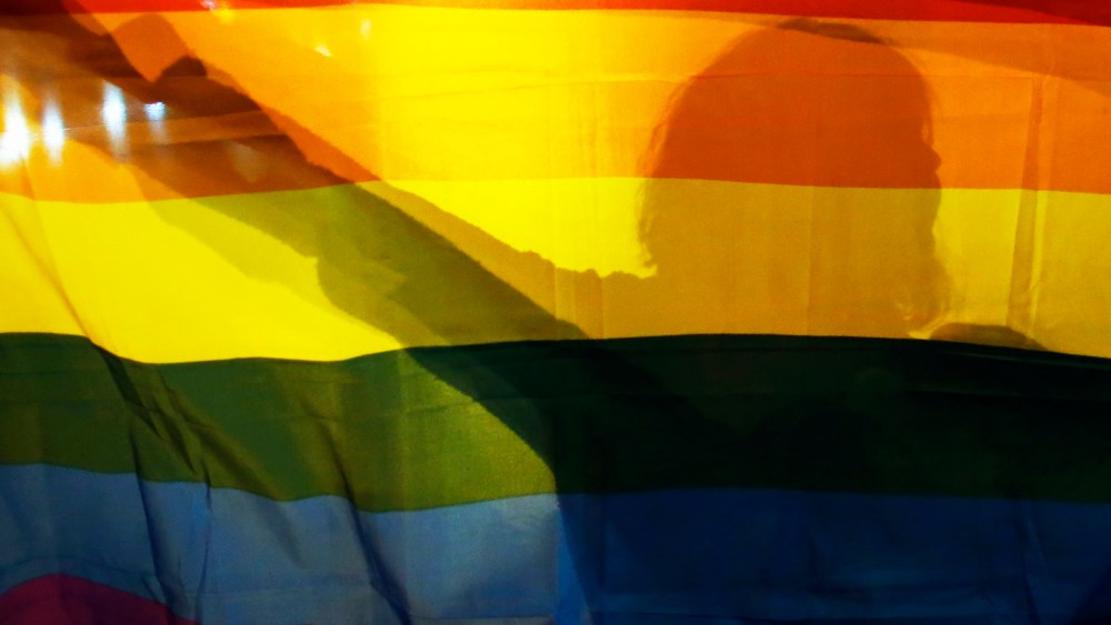 A gay rights activist holds a rainbow flag. (Photo by Marko Djurica/Reuters)