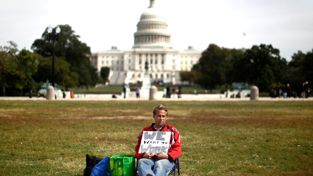 Furloughed Americorps employee Jeffrey Wismer sits alone on the Washington Mall October 8, 2013, as he calls on congress to end the government shut down.