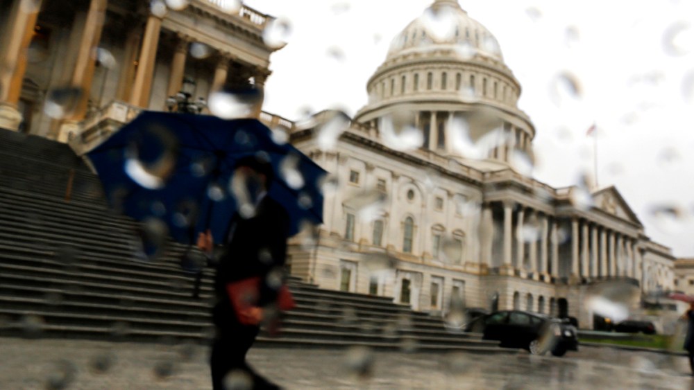 A man with an umbrella walks as it rains at the U.S. Capitol in Washington