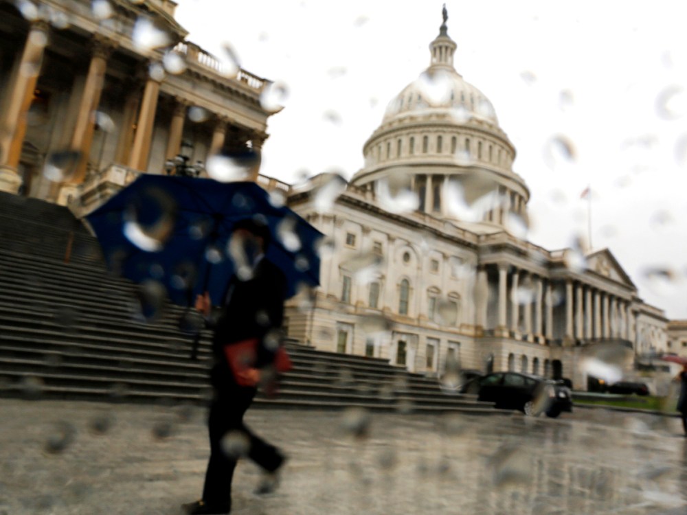 A man with an umbrella walks as it rains at the U.S. Capitol in Washington