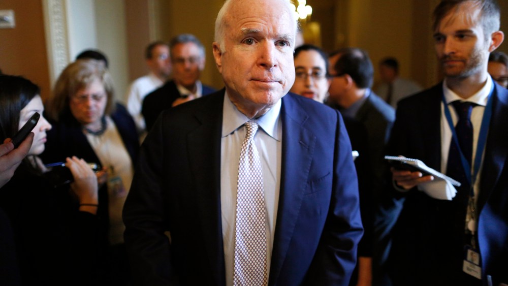 Senator John McCain (R-AZ) (C) talks to reporters on his way to the Senate floor at the U.S. Capitol in Washington, Oct. 12, 2013.
