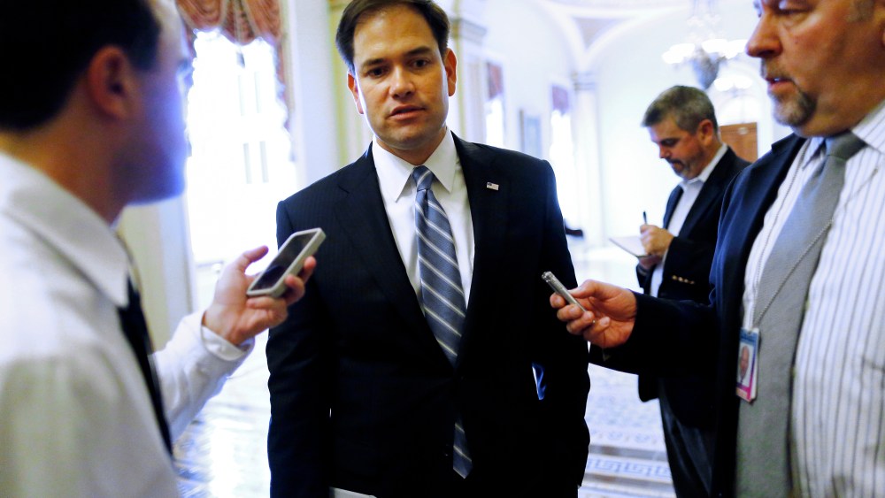 U.S. Senator Marco Rubio talks to reporters on his way to vote on the Senate floor at the U.S. Capitol in Washington, October 12, 2013.
