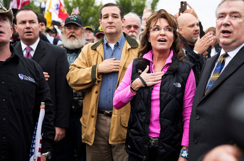 Former Alaska Governor Sarah Palin and Senator Ted Cruz (C) (R-TX) recite the Pledge of Allegiance during the "Million Vet March on the Memorials" at the U.S. National World War II Memorial in Washington on Oct. 13, 2013.