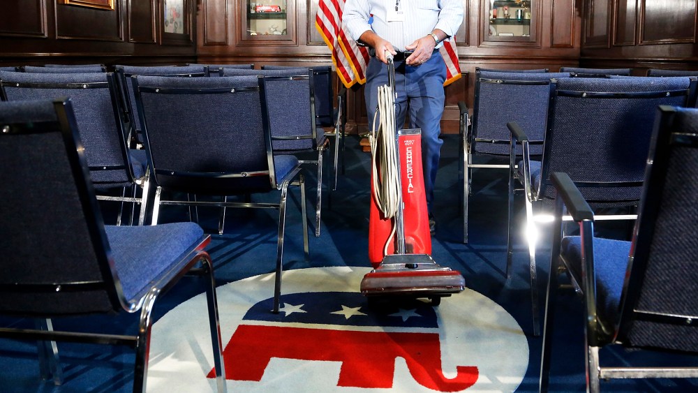 A worker prepares a room before a news conference by GOP leaders at the RNC offices in Washington, Oct. 23, 2013.