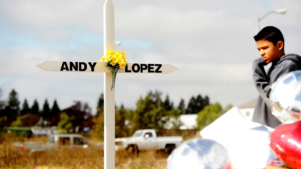 A boy passes a memorial marking the location where sheriff's deputies shot and killed 13-year-old Andy Lopez Cruz in Santa Rosa, Ca., October 27, 2013.